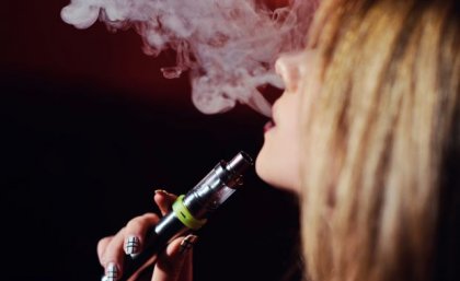 A close up of a woman vaping